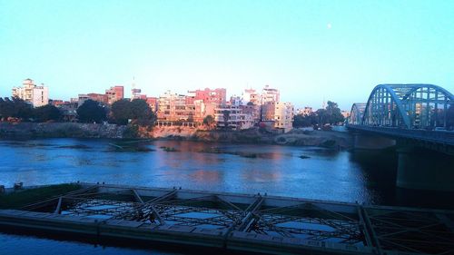 Bridge over river against buildings in city