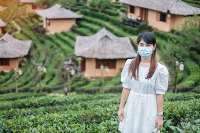 Full length of woman standing against plants