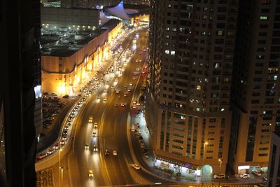 High angle view of illuminated city street and buildings at night