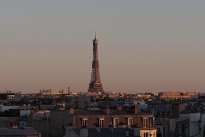 Tower and buildings against sky during sunset