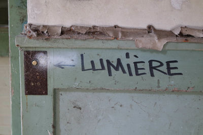 Close-up of text on metal wall