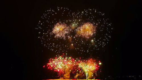 Low angle view of firework display at night
