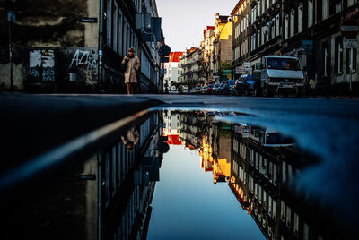 Reflection of buildings in city at sunset