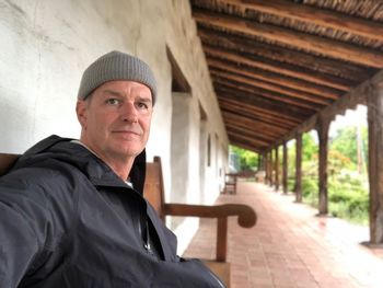 Smiling man sitting outside house