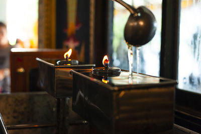 Close-up of lit candles in temple