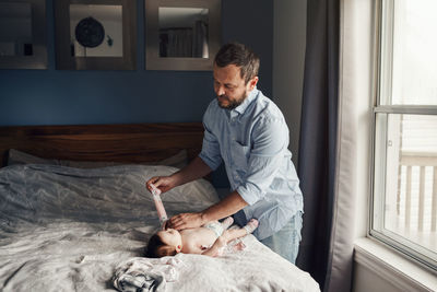 Father wearing clothes to daughter at home