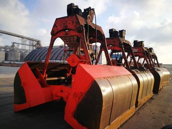 Red boat moored at shore against sky