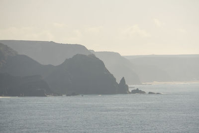 Scenic view of sea and mountains against sky