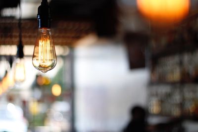 Close-up of illuminated light bulb at restaurant