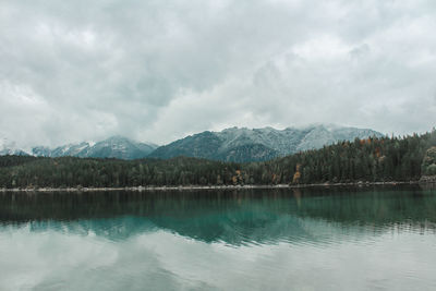 Scenic view of lake by mountains against sky