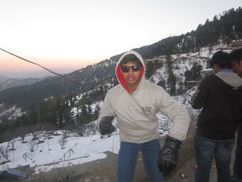 Portrait of man in sunglasses against sky during winter