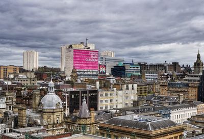 Aerial view of city against cloudy sky