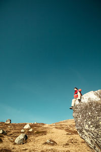 Low angle view of man on rock against sky