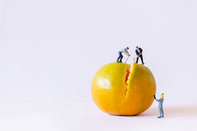 Miniature people working with orange 