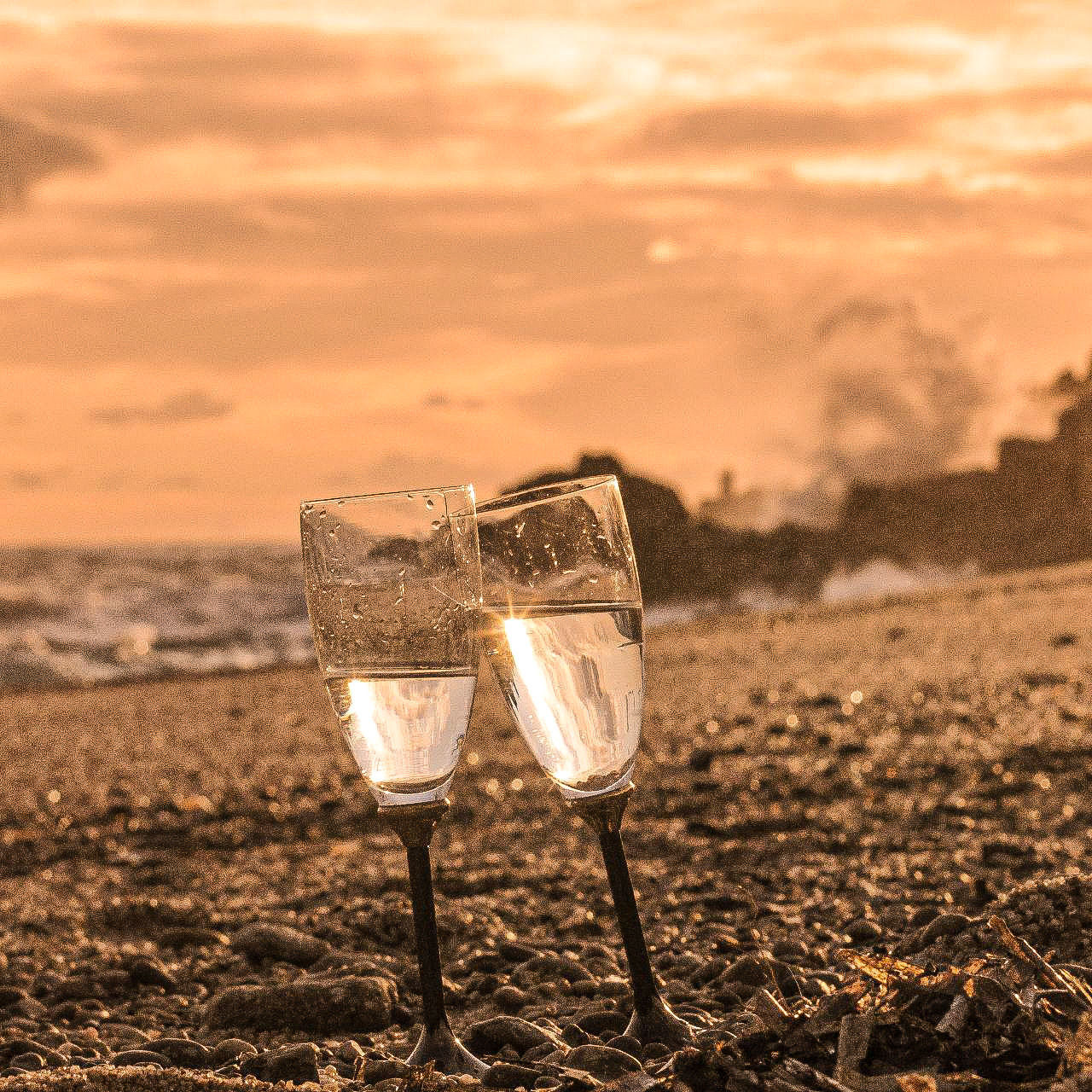 CLOSE-UP OF BEER GLASS AGAINST SUNSET