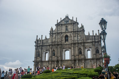 Group of people in historic building against sky