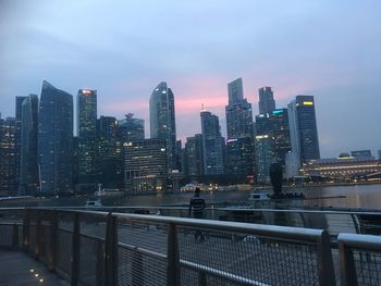 Modern buildings in city against sky at dusk