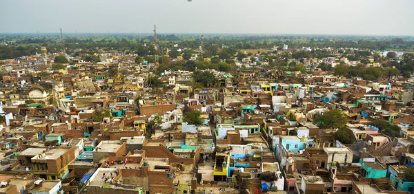 High angle shot of townscape against sky in barsana with small homes and greenery