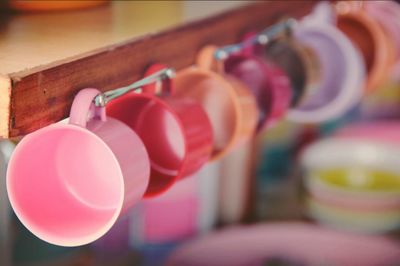 Colorful cups hanging in kitchen at home