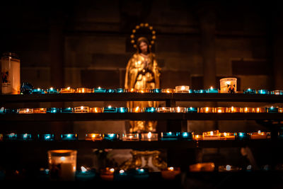 Statue against illuminated building at night