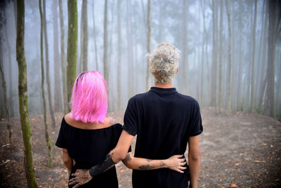 Rear view of couple standing in forest