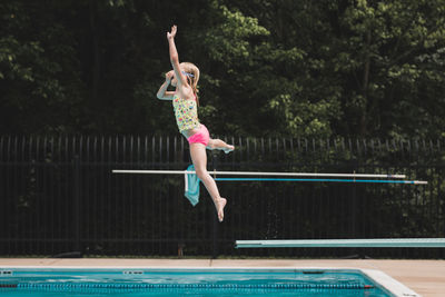 Side view of girl diving into swimming pool