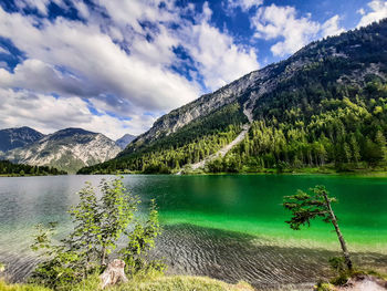 Scenic view of lake by mountains against sky