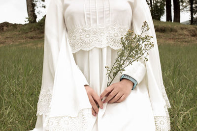 Midsection of woman standing on field