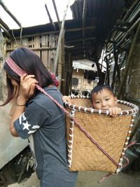 Mother carrying toddler in wicker basket