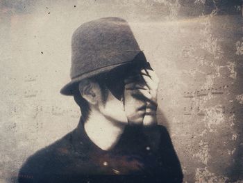 Portrait of young woman with shadow on wall