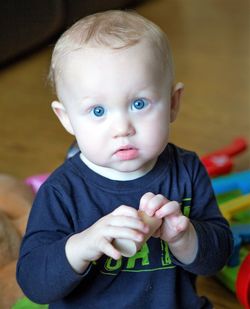 Portrait of cute baby boy playing with toy blocks at home