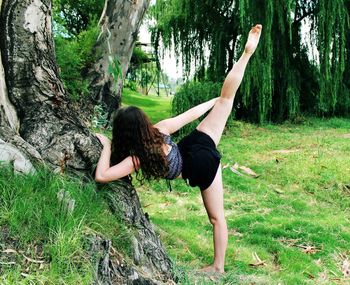 Woman standing on tree trunk