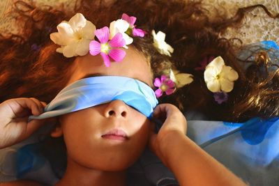 Close up portrait of a little girl lying among the flowers