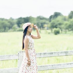 Woman looking away while standing against plants