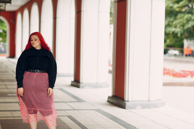 Midsection of woman standing against red wall