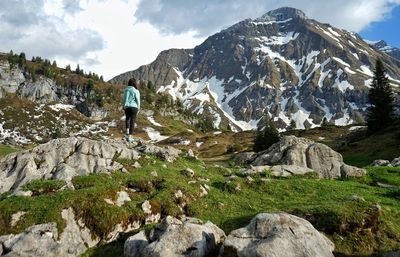 Rear view of man on rock against sky