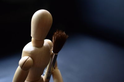 Close-up of figurine and make-up brush