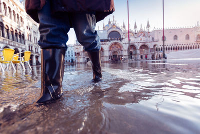 Low section of man standing in water