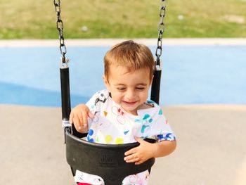 Close-up of boy on swing at playground