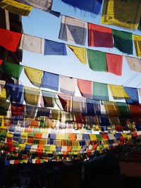 Low angle view of colorful prayer flags hanging against clear sky