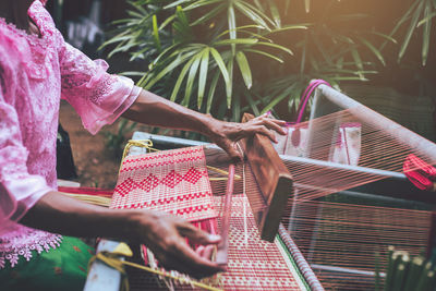 Midsection of woman with loom