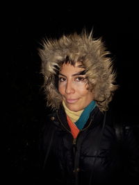 Portrait of woman in fur coat against black background