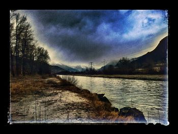 Scenic view of river against cloudy sky