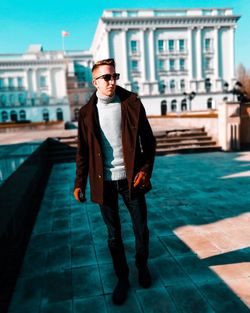 Full length portrait of young man standing in swimming pool