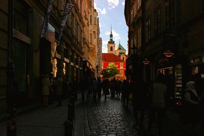 People walking on street amidst buildings in city