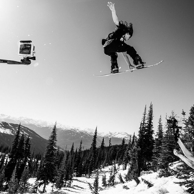 lifestyles, leisure activity, full length, men, clear sky, mid-air, jumping, extreme sports, casual clothing, skill, winter, snow, enjoyment, young adult, young men, fun, low angle view, sport