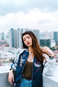 Portrait of young woman standing at building terrace