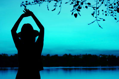 Pop art styled silhouette of lady in hat relaxing by the lake in arctic blue color