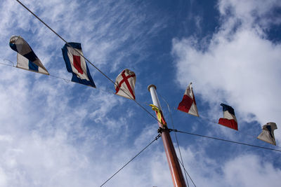 Low angle view of flags hanging against sky