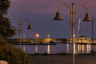 Full moon dawn in the dock of the port of riposto